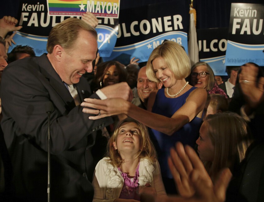 San Diego mayoral candidate Kevin Faulconer celebrates with his wife, Katherine, as their daughter looks up from below after Faulconer addressed his supporters at a rally last month in San Diego.