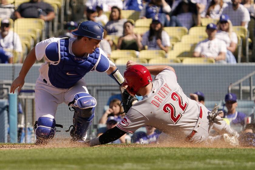 Cincinnati Reds' Brandon Drury, right, is tagged out at home by Los Angeles Dodgers catcher Will Smith while trying to score after Colin Moran grounded into a double play during the eighth inning of a baseball game Sunday, April 17, 2022, in Los Angeles. (AP Photo/Mark J. Terrill)