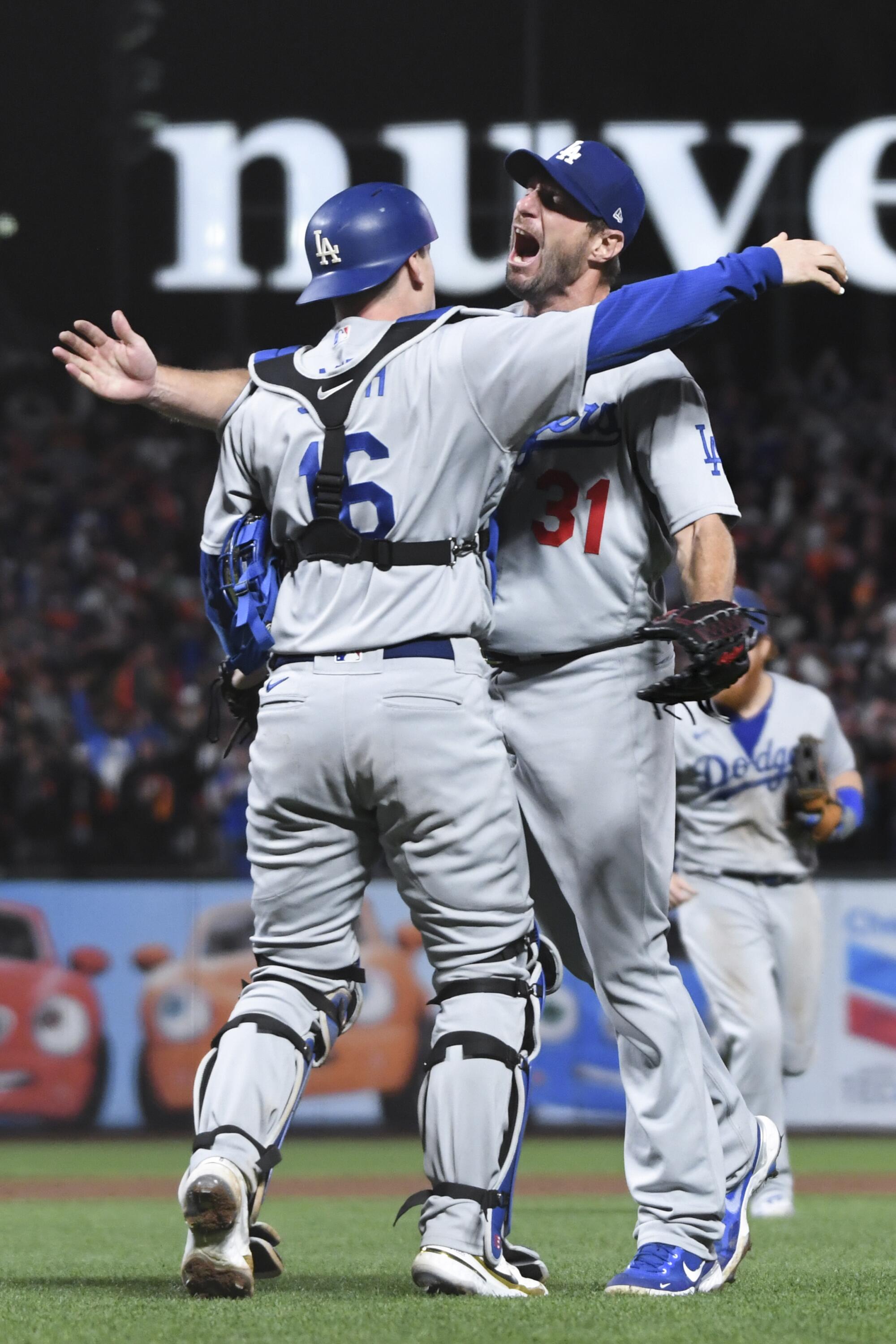 Dodgers pitcher Max Scherzer, right, celebrates with Will Smith after striking out Giants' Wilmer Flores 