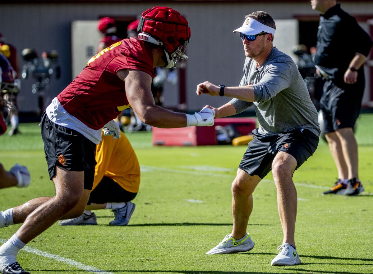 Trojans coach Lincoln Riley interacts with tight end Jude Wolfe during spring practice March 22 at USC.