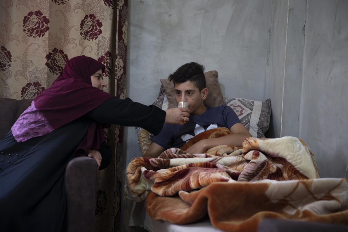 Palestinian teenager being given a drink by woman