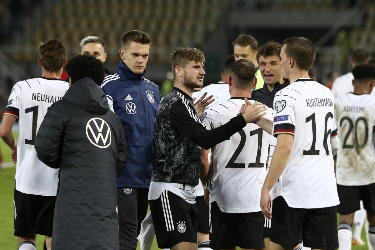 Germany's Timo Werner, left, shakes hands with Lukas Klostermann after the World Cup 2022 group J qualifying soccer match between North Macedonia and Germany at National Arena Todor Proeski stadium in Skopje, North Macedonia, Monday, Oct. 11, 2021. Germany won 4-0. (AP Photo/Boris Grdanoski)