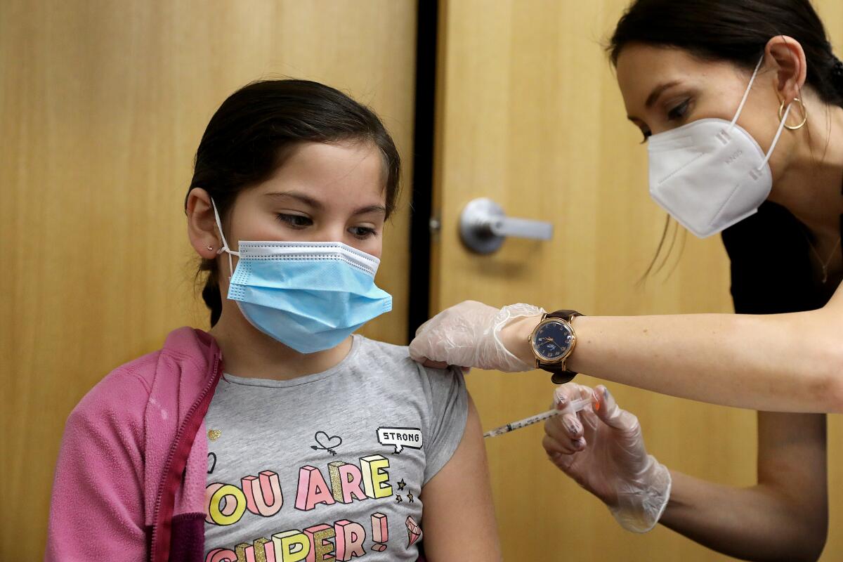 Rebecca Pimentel, 10, receives a COVID-19 vaccine
