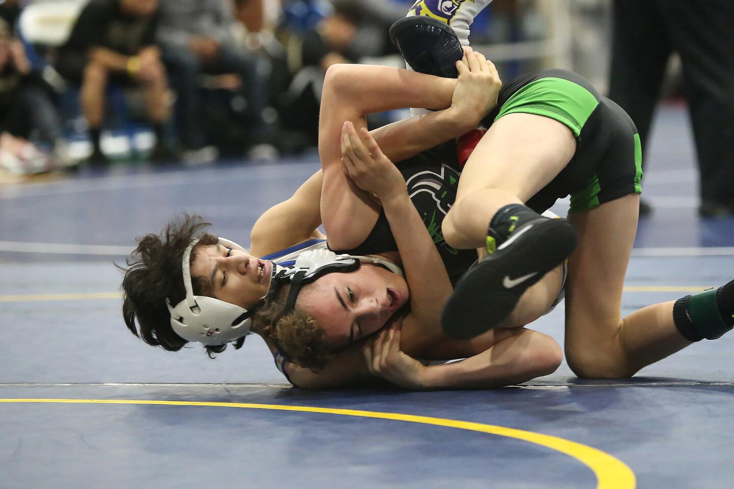 Fountain Valley's Sean Solis, left, takes down his opponent in the 106 lb. division of the Five Counties wrestling tournament at Fountain Valley High on Saturday