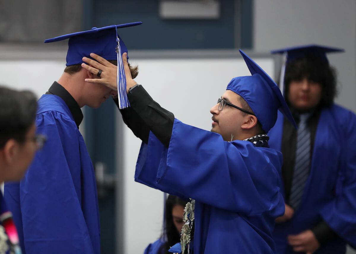 Two graduates prepare to proceed to the Valley Vista High School commencement ceremony on Thursday.