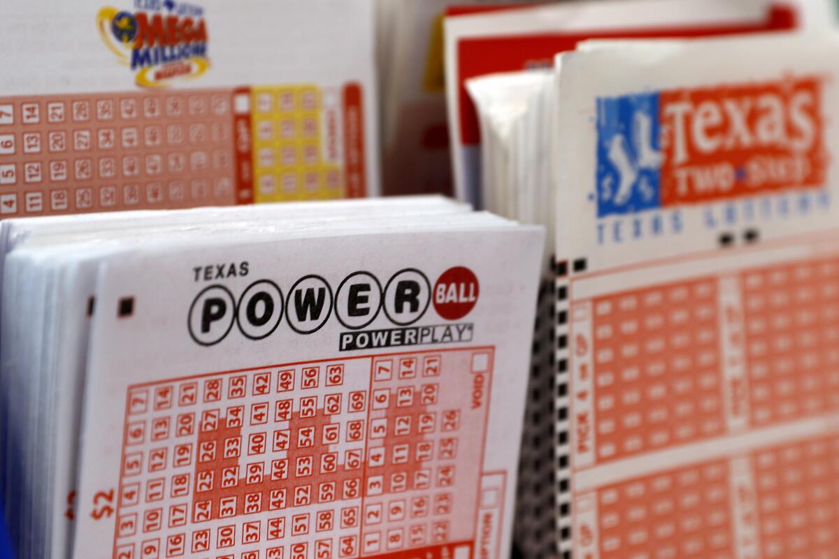 FILE - A playslip for the Power Ball lottery sits in a holder at a convenient store in Dallas, Texas, Thursday, March 26, 2020. State lotteries spend more than a half-billion dollars a year on pervasive marketing campaigns that deliver hopeful messages, designed to persuade people to play often, spend more and overlook the long odds of winning. But for every dollar players spend on the lottery, they will lose about 35 cents on average, according to an analysis of lottery data by the Howard Center for Investigative Journalism at the University of Maryland. (AP Photo/Tony Gutierrez, File)