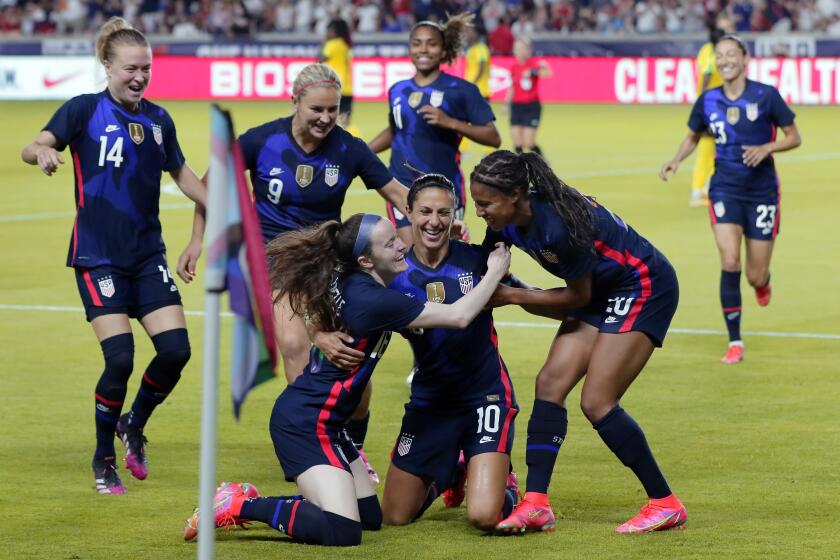 USA forward Carli Lloyd (10) is swarmed by her team mates after scoring a goal against Jamaica during the first half of their 2021 WNT Summer Series match Sunday, June 13, 2021, in Houston. (AP Photo/Michael Wyke)