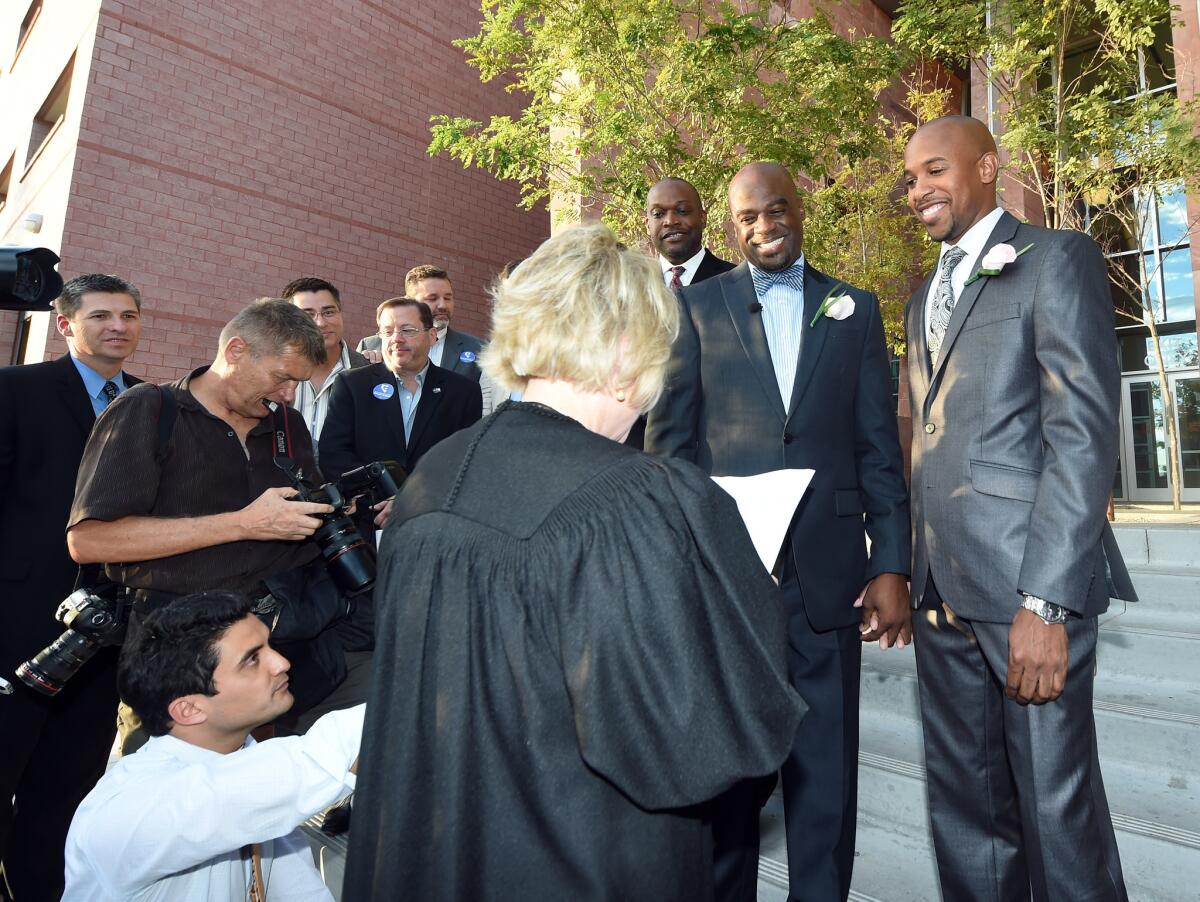 Judge Nancy Allf marries Sherwood Howard, right, and Nevada state Sen. Kelvin Atkinson (D-North Las Vegas) outside the Clark County Marriage Bureau on Oct. 9.
