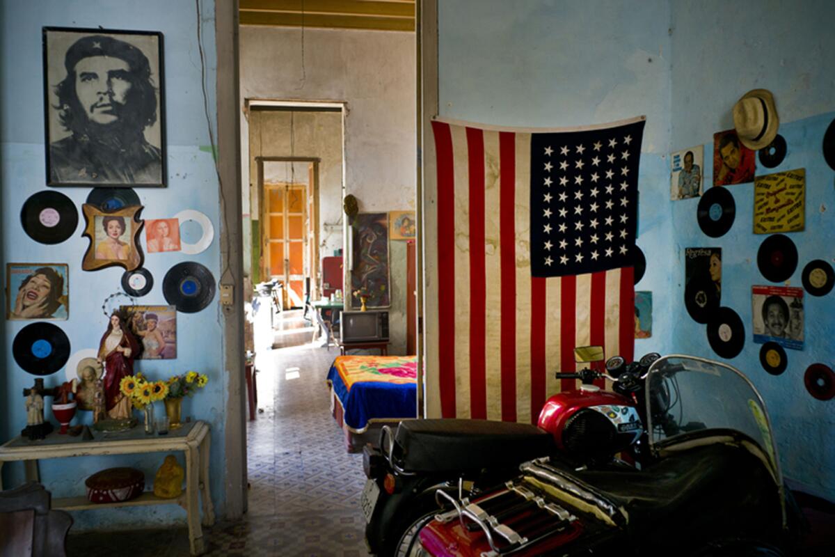 Una foto del revolucionario Ernesto "Che" Guevara está en una pared y en la otra hay bandera de EEUU en una vivienda en La Habana, Cuba. (Foto AP / Ramón Espinosa)