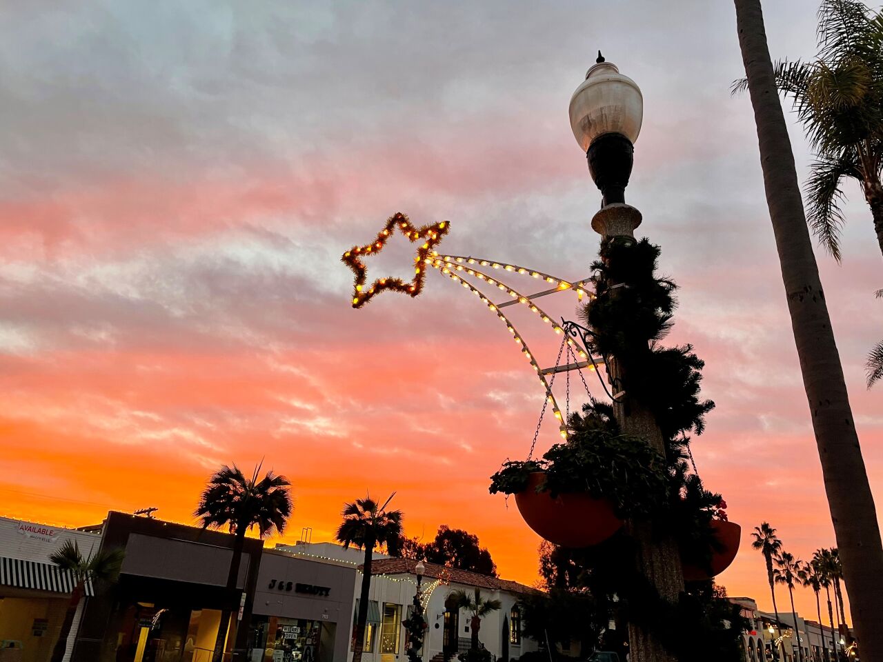An orange sunrise is seen from the decorated corner of Prospect Street and Girard Avenue on Dec. 8.