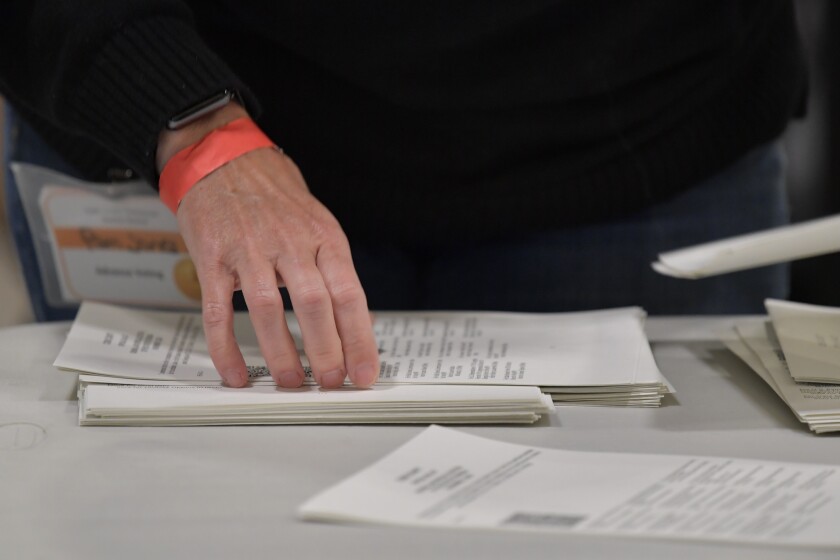 Cobb County election officials handle ballots during an audit in Marietta, Ga.