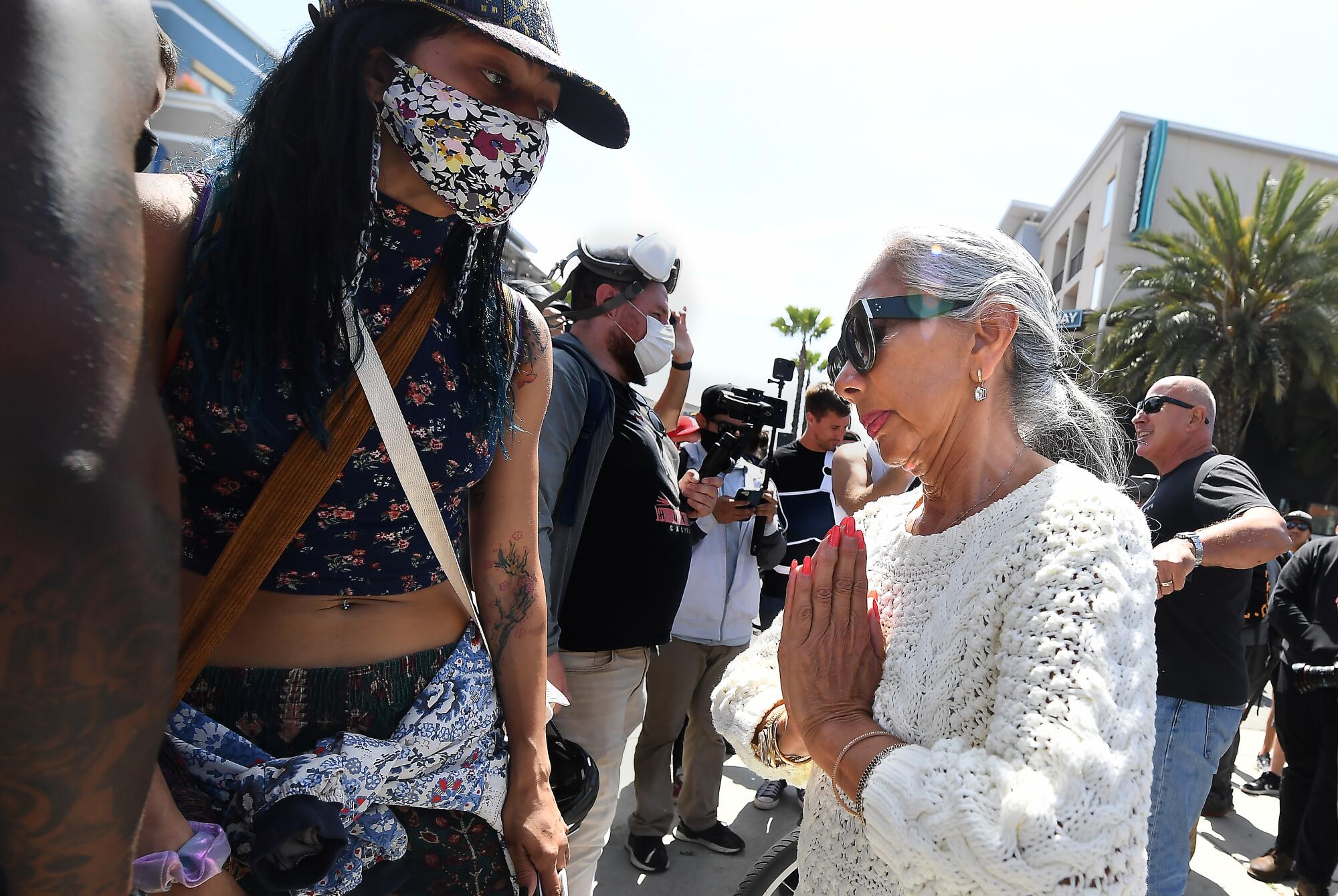A woman clasps her hands as she talks to a Black Lives Matter supporter
