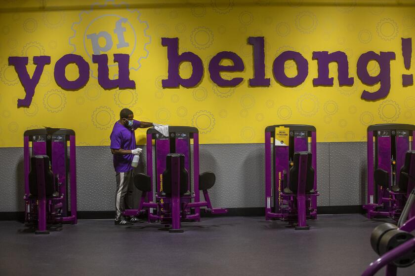 INGLEWOOD, CA - MARCH 15: Anthony Carthan, an employee at Planet Fitness on Imperial Highway in Inglewood, disinfects exercise equipment while helping to prepare the fitness center for their re-opening tomorrow morning at 5am after being closed since July of 2020. Exercise equipment is spaced apart to ensure social distancing and the new guidelines allow for a maximum of 10 percent of capacity. (Mel Melcon / Los Angeles Times)