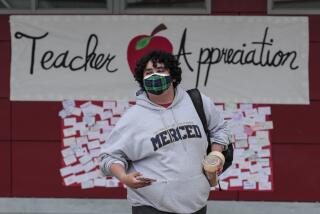 Baldwin Park, CA, Thursday, May 6, 2021 - Starbucks in one hand, smartphone in the other, Jesus Medina looks for teachers arriving on campus at Sierra Vista High, to add to his collection of selfies minutes after hanging a teacher appreciation banner. (Robert Gauthier/Los Angeles Times)