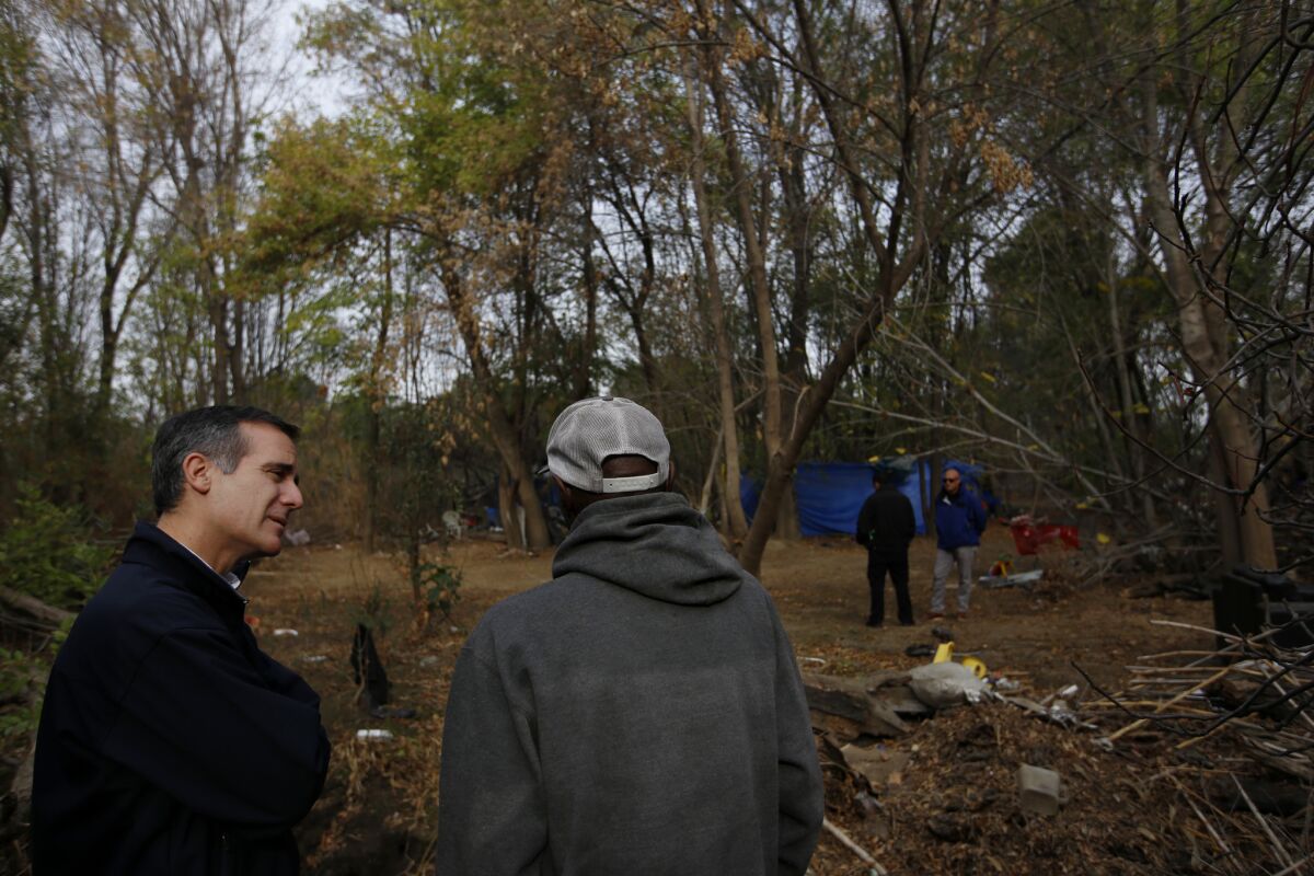 Mayor Eric Garcetti, left, visits a homeless encampment near the Sepulveda Basin in Encino in 2016.