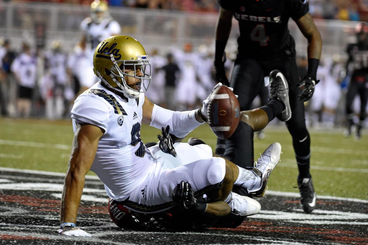 UCLA's Jordan Payton is tackled by a UNLV defender in the end zone after scoring a touchdown during their game on Saturday.