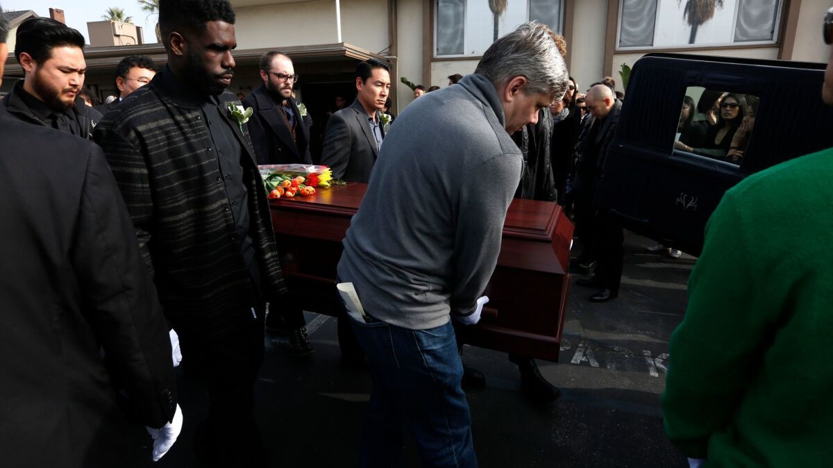 Friends and family carry the casket of Ara Jo at the end of her funeral services.