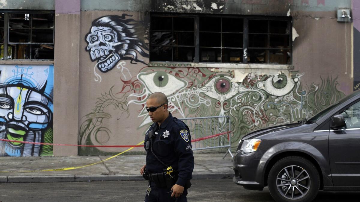 An Oakland police officer guards the area in front of the art collective warehouse known as the Ghost Ship in the aftermath of the December 2016 fire that killed 36 people.