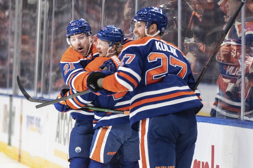 Edmonton Oilers' Adam Erne (21), James Hamblin (57) and Brett Kulak (27) celebrate a goal against the Anaheim Ducks during the second period of an NHL hockey game in Edmonton, Alberta, on Sunday, Nov. 26, 2023. (Jason Franson/The Canadian Press via AP)