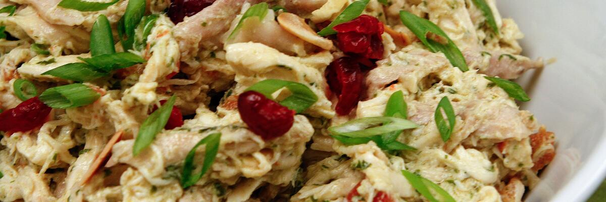 Chicken Salad from the Curious Palate features almonds and cranberries garnished with sliced green onion.