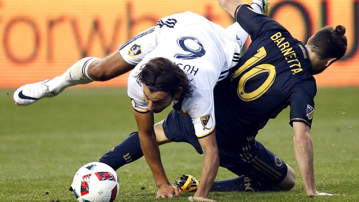Galaxy midfielder Baggio Husidic and Union midfielder Tranquillo Barnetta (10) get tangled while vying for control of the ball during their game Wednesday.