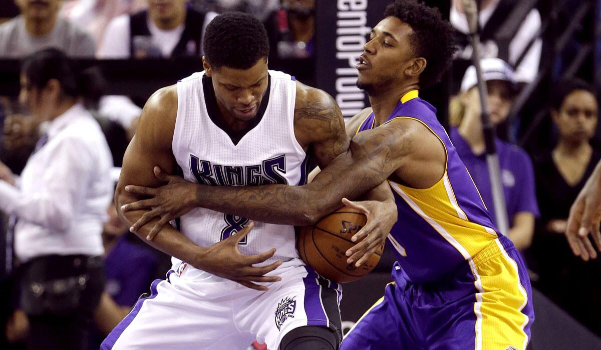 Lakers forward Nick Young tries to steal the ball from Kings forward Rudy Gay in Sunday's game in Sacramento.