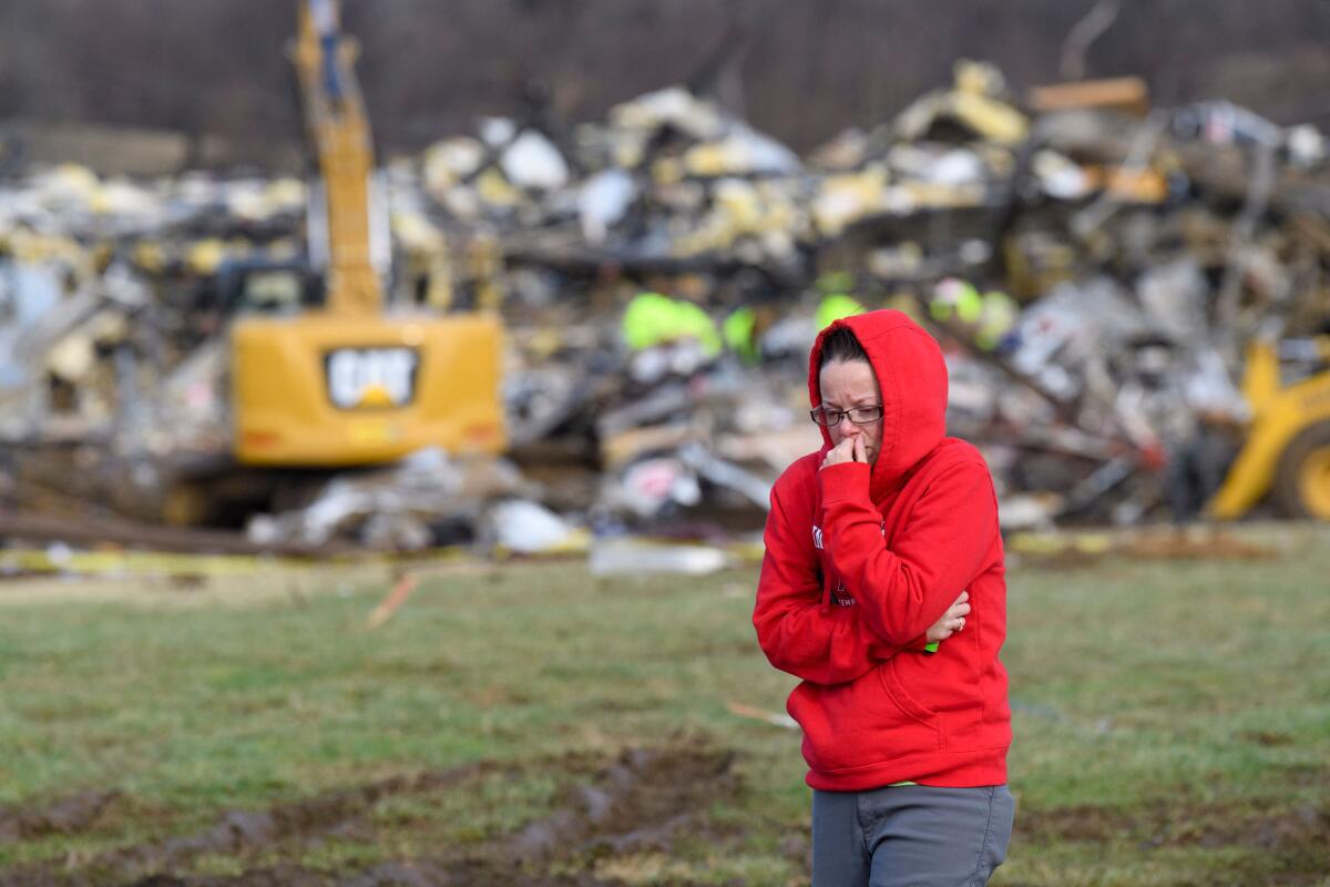 A woman walks away from what is left of the Mayfield Consumer Products candle factory
