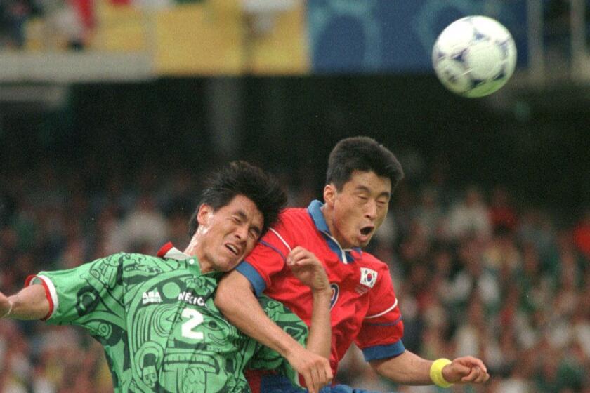 Mexico's Claudio Suarez, left, battles for the ball with South Korea's Kim Do Hon during the South Korea vs. Mexico, Group E, World Cup 98, soccer match at Gerland stadium in Lyon, Saturday, June 13 1998. The other teams in group E are Belgium and Netherlands. Mexico defeated South Korea 3?1. (AP Photo/Eric Draper)