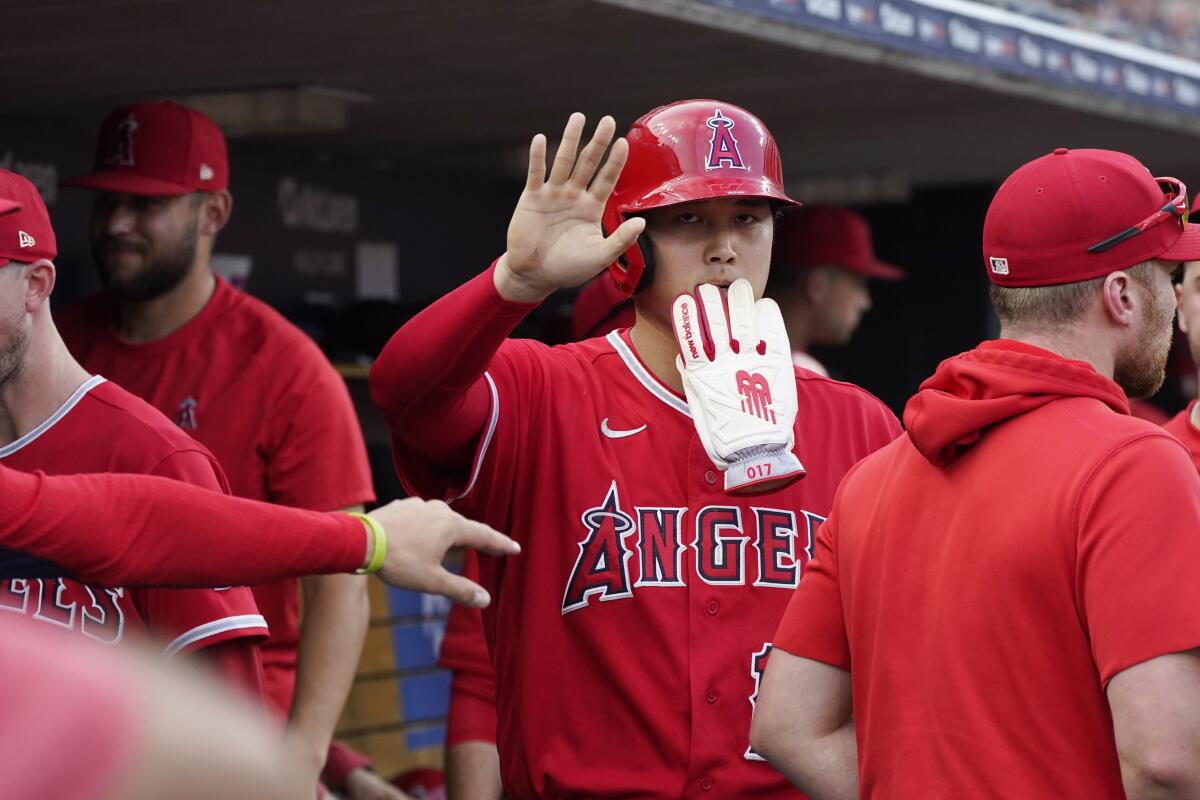 Angels designated hitter Shohei Ohtani is greeted in the dugout after scoring.