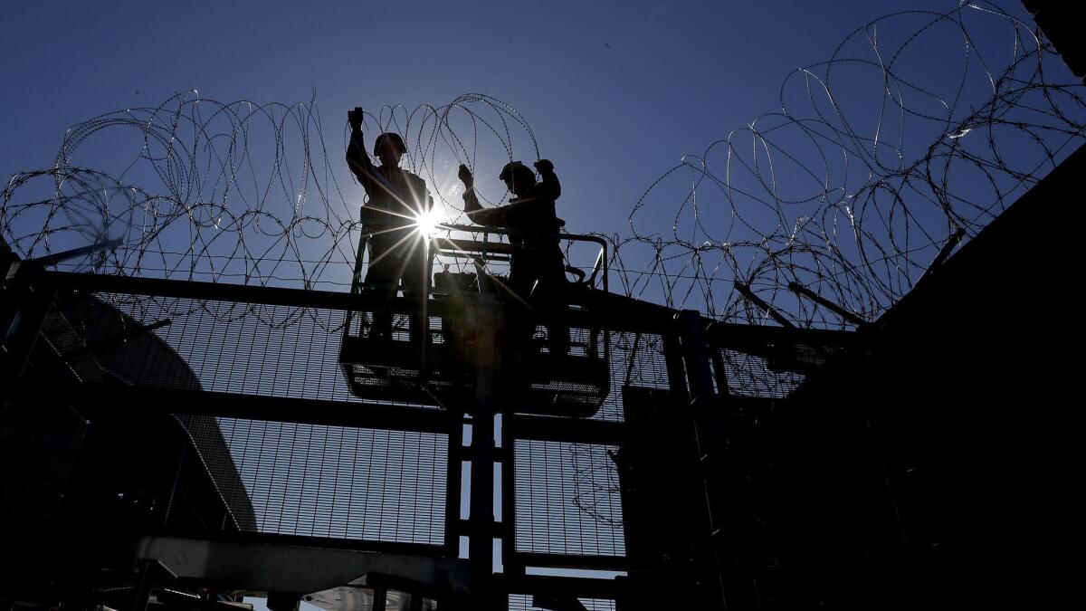Marines from Camp Pendleton install razor wire at the San Ysidro border crossing Friday.