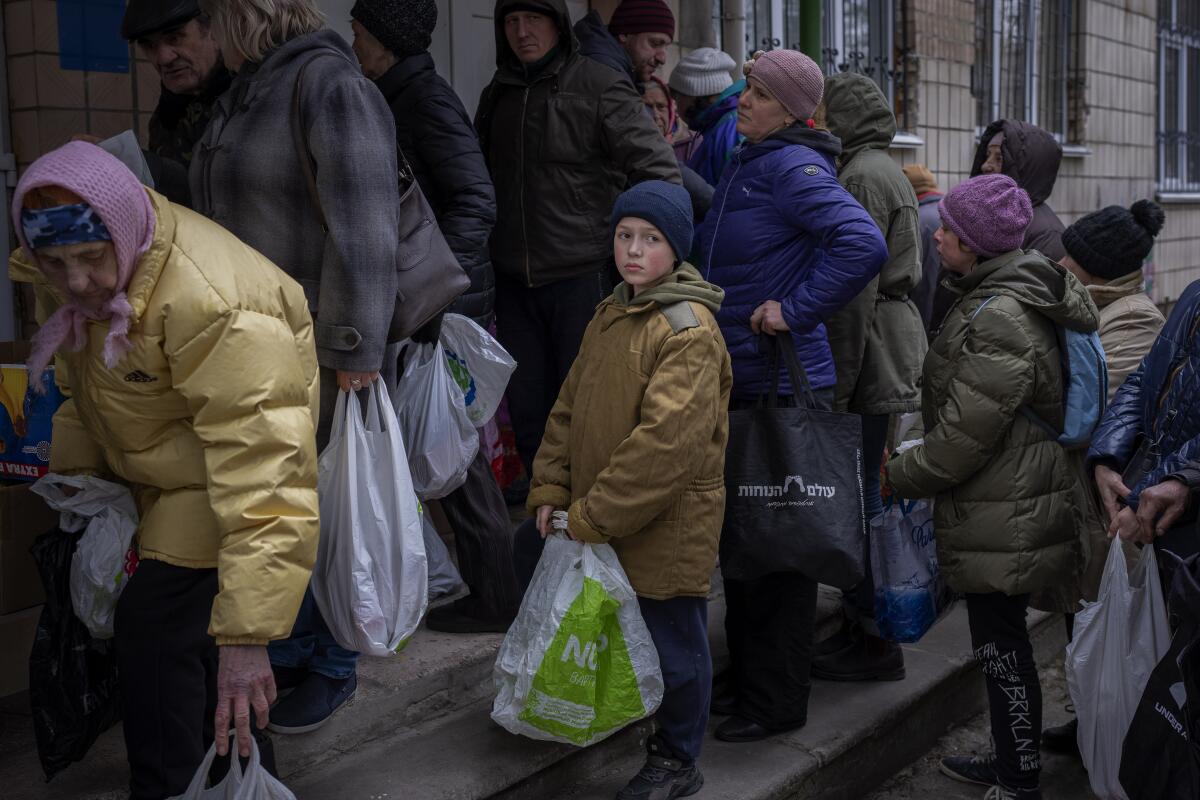 Sergei, de 11 años, espera su turno para recibir alimentos donados en Bucha, en las afueras de Kiev