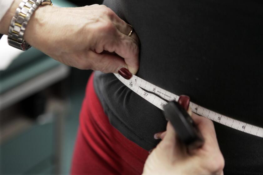 A subject's waist is measured during an obesity prevention study in Chicago. 