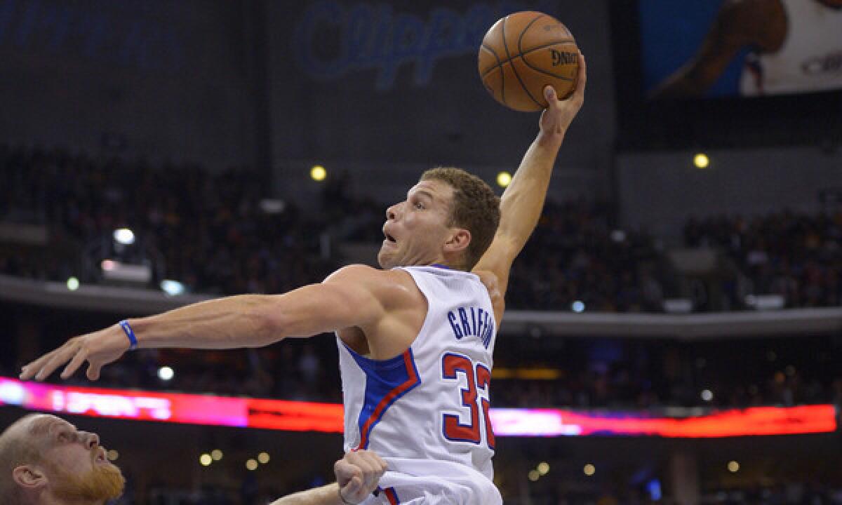Clippers forward Blake Griffin, right, dunks over Lakers center Chris Kaman during the Clippers' win on Friday.