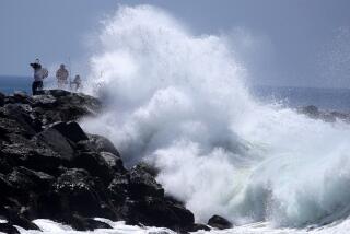 NEWPORT BEACH, CALIF. - JULY 20, 2022. Fishermen are dwarfed by a big wave crashing at The Wedge in Newport Beach on Wednesday, July 20, 2022.. High surf advisories are in effect for beaches from San Diego to Ventura as big waves from a South Pacific storm pound the shoreline. (Luis Sinco / Los Angeles Times)