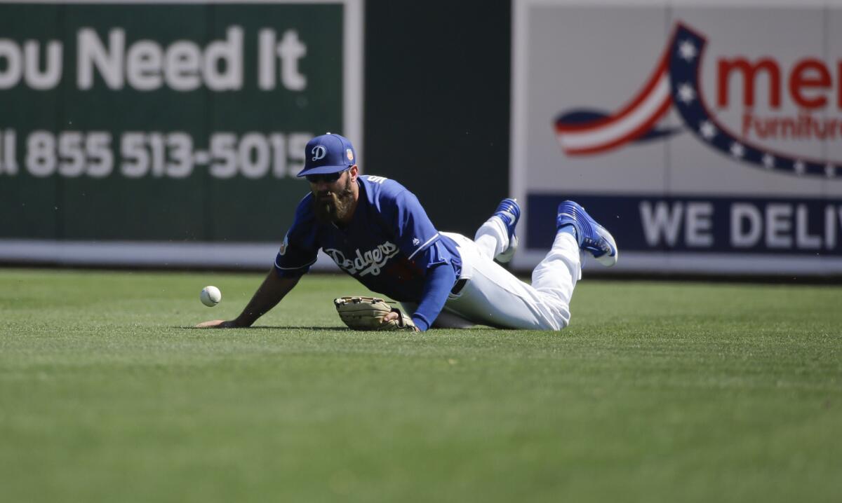 Dodgers outfielder Scott Van Slyke misses a ball hit by Reds outfielder Jay Bruce during a spring training game on Mar. 27.