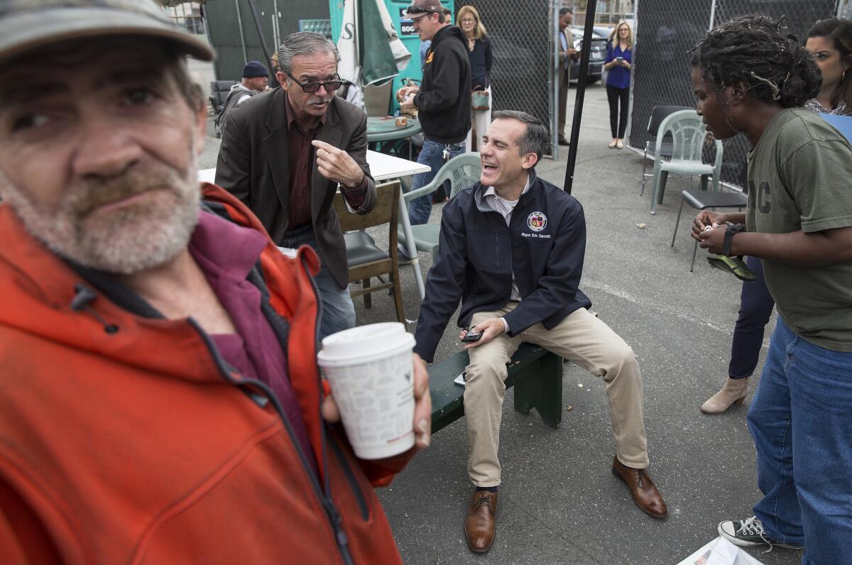 Los Angeles Mayor Eric Garcetti, center, talks with homeless people at The Center at Blessed Sacrament Hollywood.