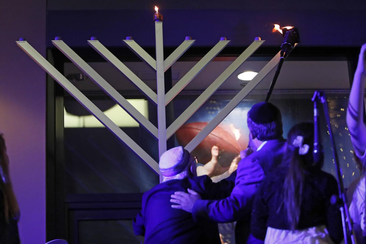 Holocaust survivor Jacob Eisenbach, left, and Rabbi Reuven Mintz of the Chabad Center for Jewish Life light the menorah at Fashion Island in Newport Beach in 2017. This year’s lighting is Sunday, the first evening of Hanukkah.
