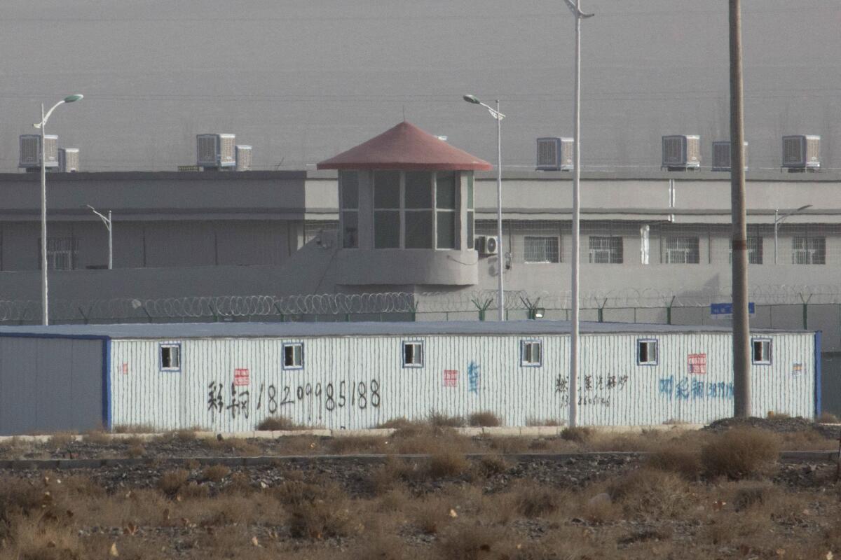 A guard tower and fences are seen around a facility in China's Xinjiang region.