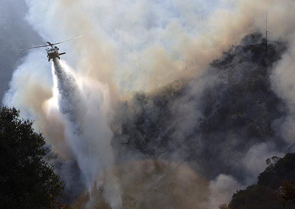 A helicopter makes a drop over the fire burning in the Angeles National Forest north of La Ca?ada Flintridge.