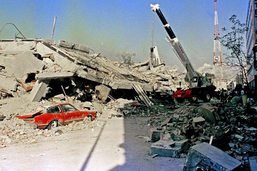 A car sits under rubble after the 1985 Mexico City earthquake
