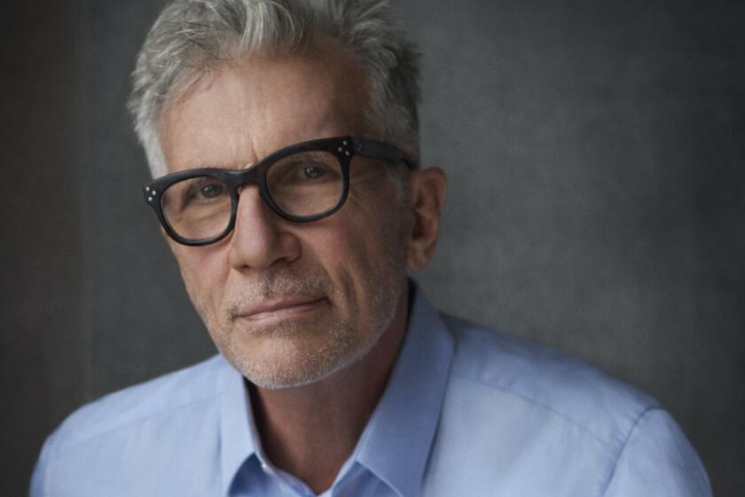 Michael Cunningham, an author with a neat gray haircut, black-framed glasses and a blue dress shirt.