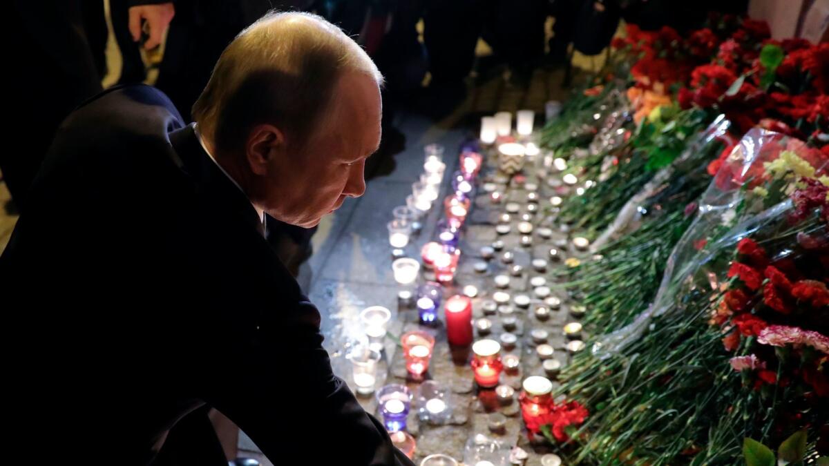 Russian President Vladimir Putin lays flowers after a bomb attack in St. Petersburg, Russia.