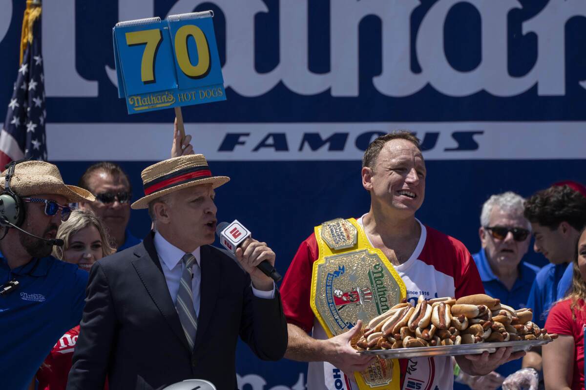 Competitive eater Joey Chestnut celebrates after winning the 2025 Nathan's Famous Fourth of July hot dog eating contest.