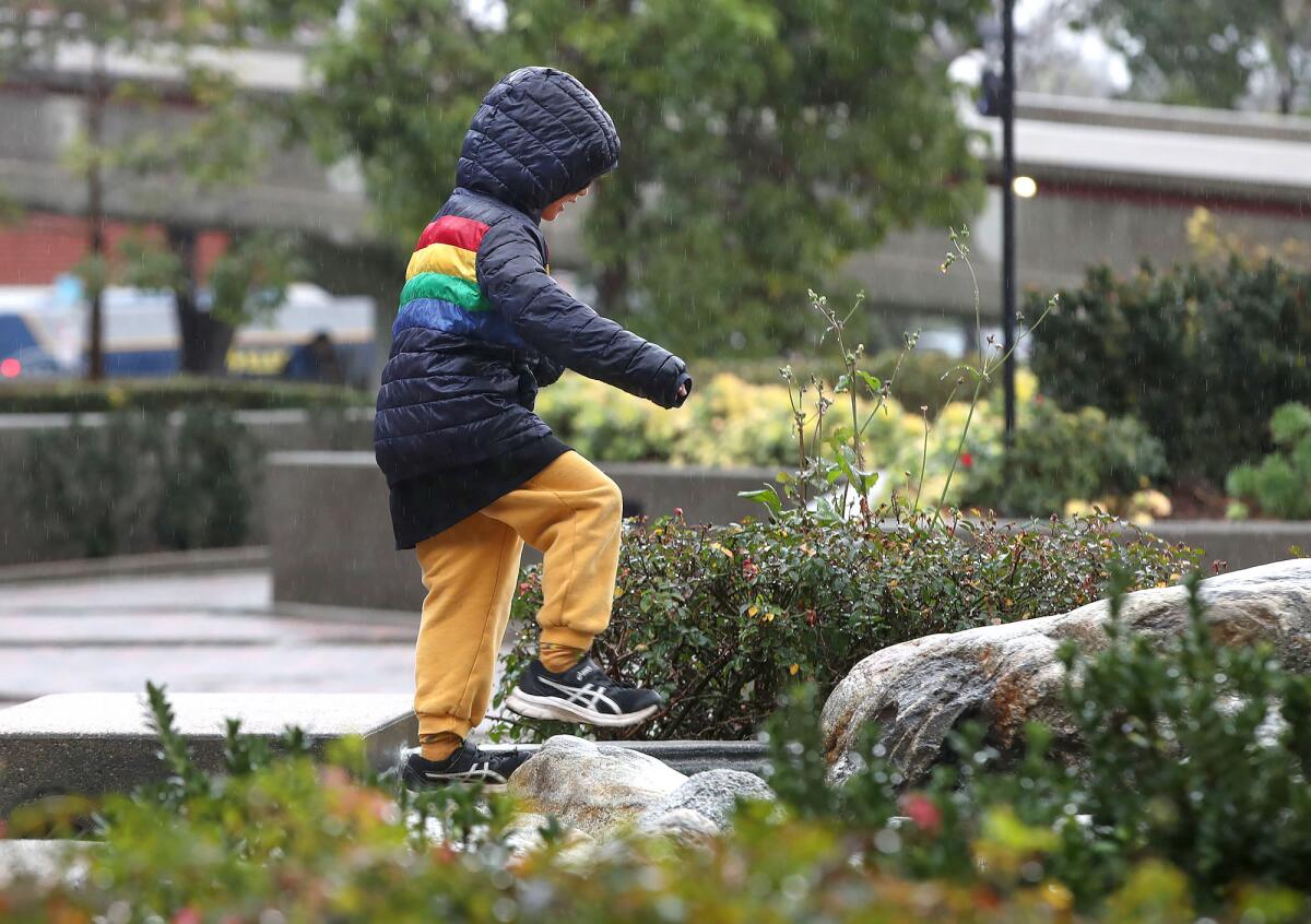 A youngster climbs rocks under a light rain as he waits for the Lunar New Year celebration.