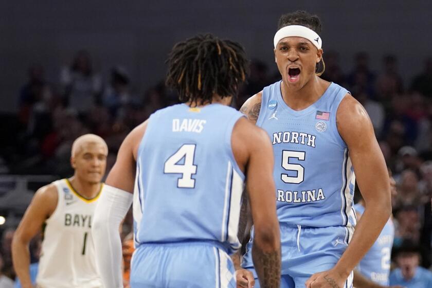 North Carolina guard RJ Davis (4) and forward Armando Bacot (5) celebrate in the second half of a second-round game against Baylor in the NCAA college basketball tournament in Fort Worth, Texas, Saturday, March, 19, 2022. (AP Photo/Tony Gutierrez)