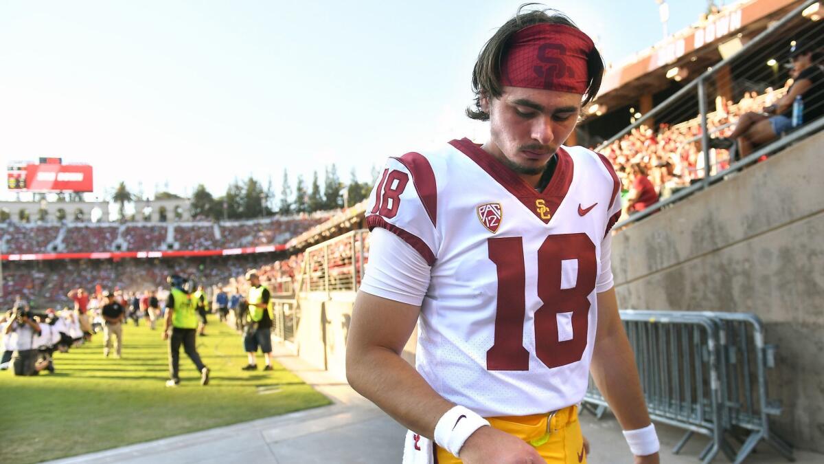 USC quarterback JT Daniels looks at his throwing hand as he heads to the locker room during a game against Stanford at Stanford Stadium on Saturday.