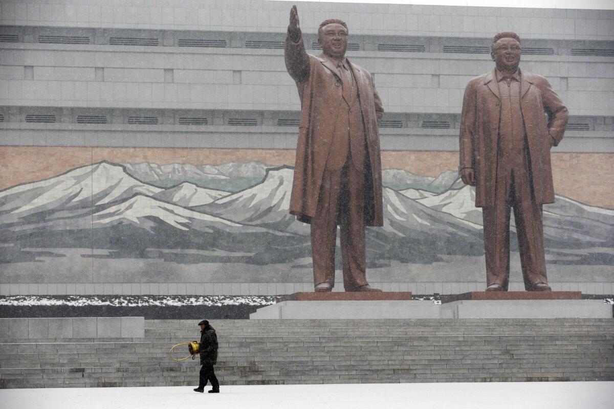 Statues of late North Korean leaders Kim Il Sung, left, and Kim Jong Il stand amid falling snow Friday at Mansu Hill in Pyongyang, North Korea.