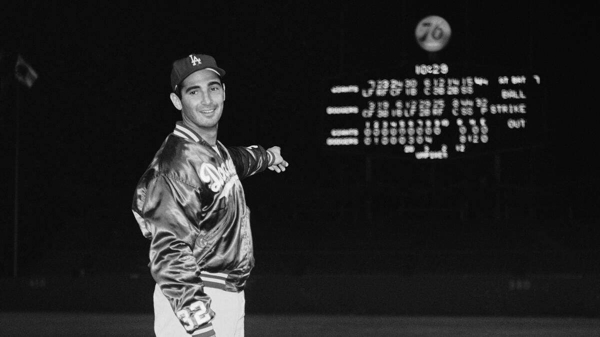 Sandy Koufax points at the Dodger Stadium scoreboard after throwing a perfect game against the Chicago Cubs on Sept. 9, 1965.