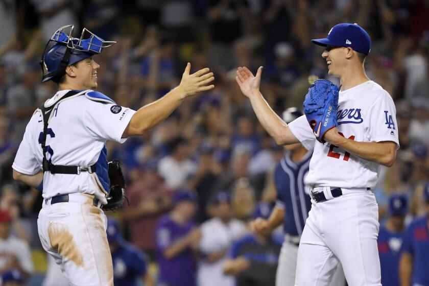 Dodgers catcher Will Smith, left, and starting pitcher Walker Buehler congratulate one another.