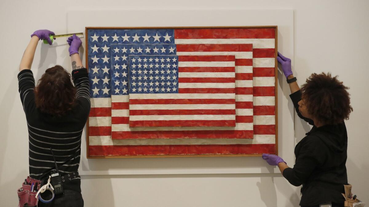 Installers mount "Three Flags" in preparation for the opening of "Jasper Johns: Something Resembling Truth" at the Broad museum in downtown L.A.